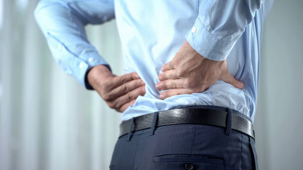 Office worker feeling sharp back pain, sedentary lifestyle, slipped disc Office worker feeling sharp back pain, sedentary lifestyle, slipped disc office back pain stock pictures, royalty-free photos & images