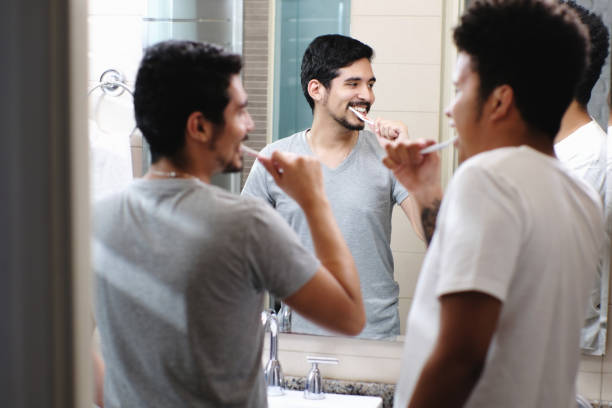 istock Happy Gay Couple Brushing Teeth In Bathroom 1076963776