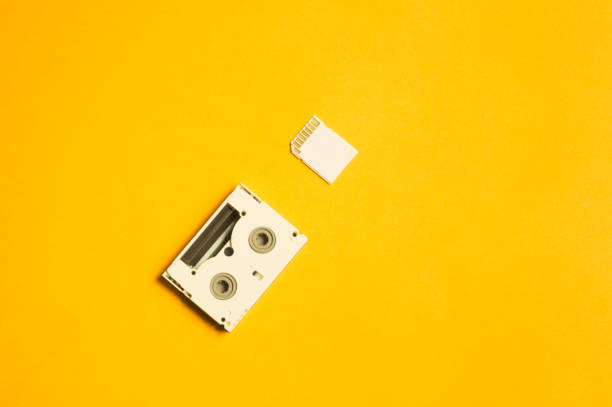 istock Memory card and digital video cassette on yellow background. copy space 1076964164