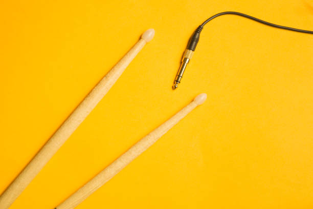 istock Used drumsticks and audio jack isolated on yellow background. copy space 1076967736