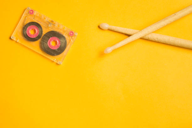 istock Drumsticks and audio cassette on yellow background 1076967874