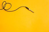 Audio jack with black cable isolated on yellow background