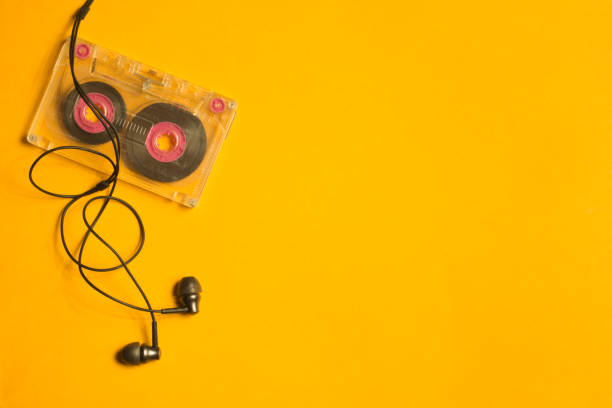 istock Earphones and retro cassette on yellow background. copy space 1076968076