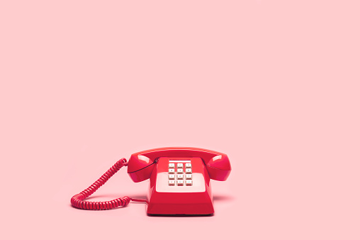 Teléfono retro color rosa sobre fondo rosa photo