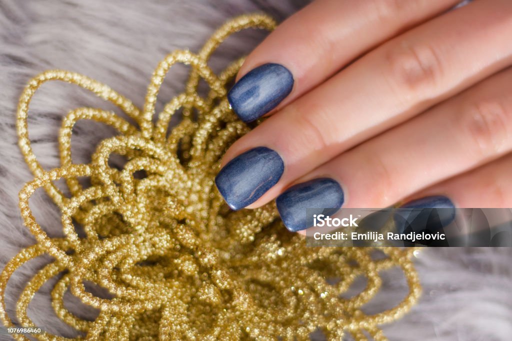 Foto de Mão De Mulher Com Unhas Azul Marinho Polonês Gel Sobre As Unhas E  Decorativo Flor Dourada e mais fotos de stock de Adulto - iStock