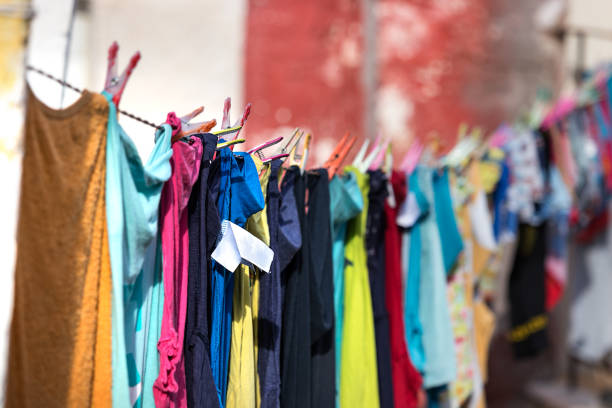 istock Multicolored clothes hanged and drying in a line outdoors a house, Pylos, Greece. 1076993158