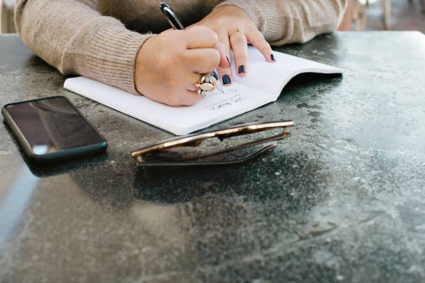 istock A Young Woman Begins to Write Down Her Life Goals in a Journal 1077004496