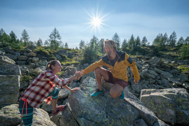 istock Hiker assists teammate on mountain trail, Switzerland 1077019724
