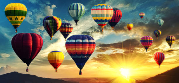Hot air balloon above high mountain at sunset