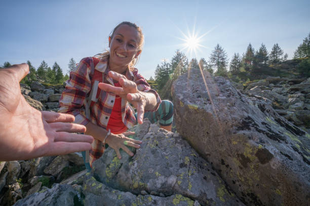 istock Hiker assists teammate on mountain trail climbing rocks 1077023202