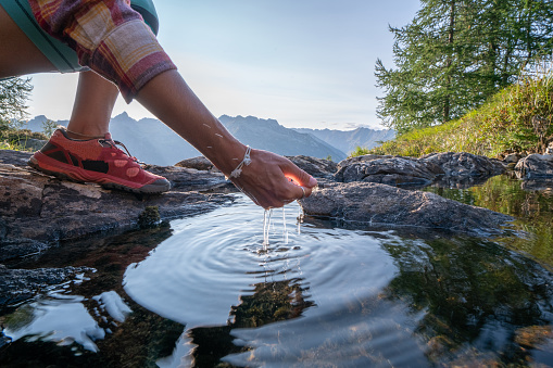 Human hand cupped to catch the fresh water from the lake, reflection on water surface
Shot in Switzerland
