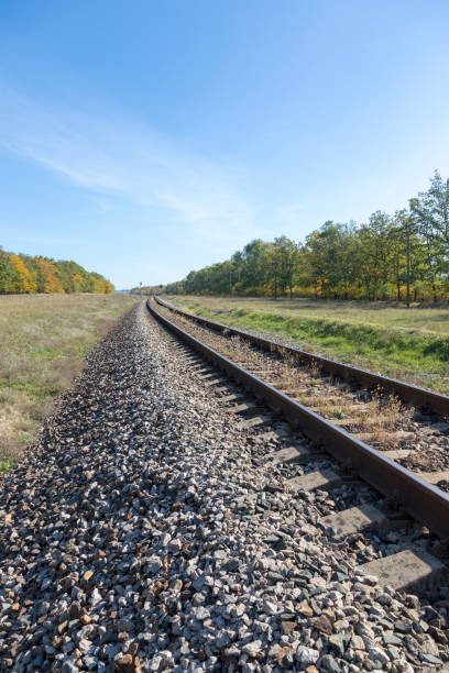 istock Autumn landscape with railway and oak grove 1077031116