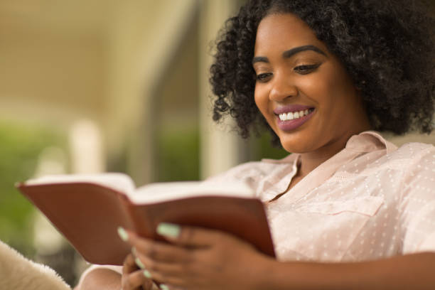 szczęśliwa kobieta czyta. - reading religious text black bible zdjęcia i obrazy z banku zdjęć