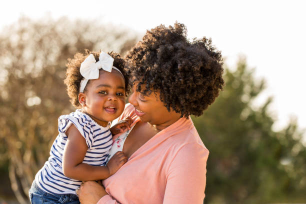 istock African American mother picking up her daughter. 1077038180