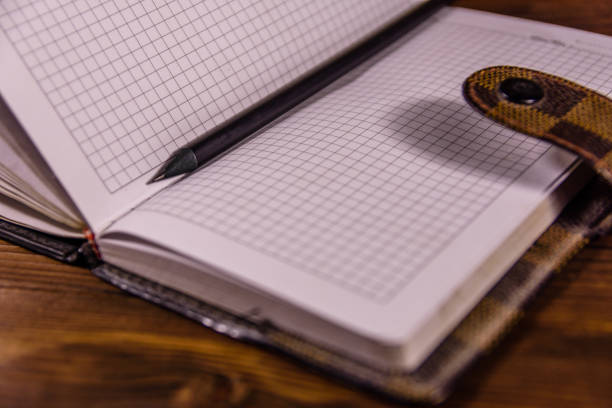 istock Opened notepad and pencil on wooden table 1077040374