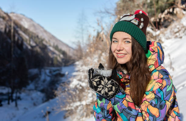 jeune fille aime les chutes de neige. jeune femme en forme de tricot est boire du thé dans la forêt pendant une chute de neige. photo tonique - 13412 photos et images de collection