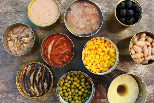 istock Different open canned food on old wooden background. Top view. Flat lay. 1077041308