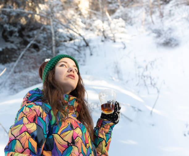 女の子は、雪の滝を楽しんでいます。ニット形で若い女性は、降雪時森の中お茶を飲んでいます。トーンの写真 - 13422 ストックフォトと画像