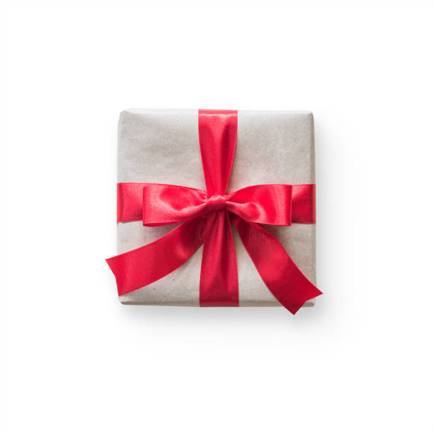 istock Gift box present (isolated with clipping path) with red bow satin ribbon over brown wrapping paper on white background for Christmas and birthday greeting card design decoration template 1077044292