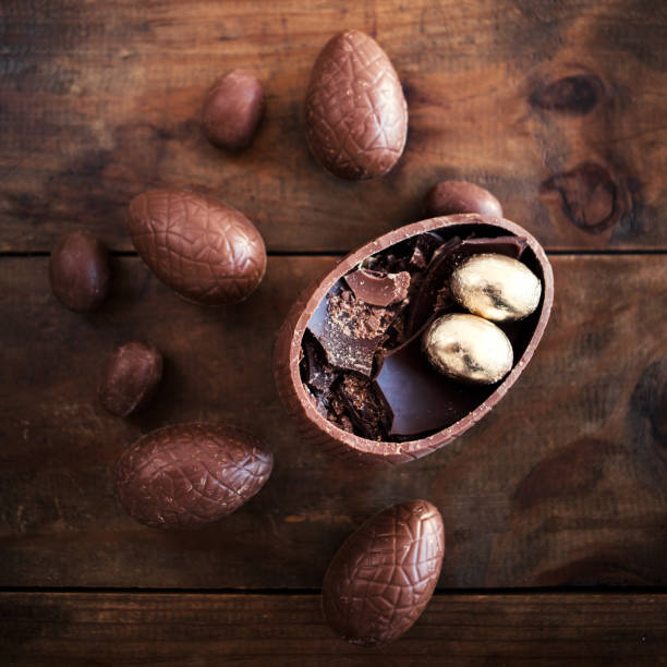 istock Chocolate Easter eggs on wooden background with ribbon bow and candies. Happy Easter!