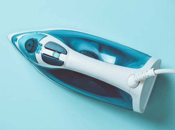 istock Iron on a blue pastel background. Top view. The ironing of things. 1077049080