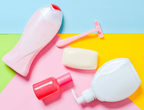 Products for the care of body, hair and personal hygiene on a multi-colored paper background. A bottle of fragrant perfume, lotion, shampoo, soap, razor. Top view. Trend of minimalism. Flat lay. productos para el cuidado del cuerpo, el pelo y la higiene personal, sobre un fondo de papel multicolor. una botella de fragante perfume, loción, champú, jabón, maquinilla de afeitar. vista superior. tendencia del minimalismo. la endecha plana.