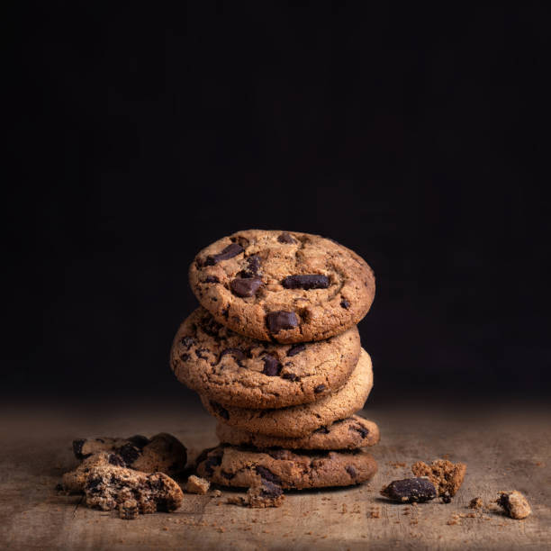 cookies de chocolate na mesa de madeira rústica. biscoito de chocolate no fundo preto com espaço de cópia de texto, closeup. - oat oatmeal isolated stack - fotografias e filmes do acervo