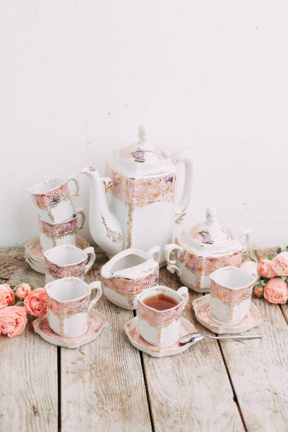 istock tea set in composition with flowers and marshmallows. Coffee mug on a saucer, a teapot and a sugar bowl. 1077055172