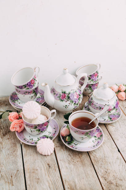 istock tea set in composition with flowers and marshmallows. Coffee mug on a saucer, a teapot and a sugar bowl. 1077055222