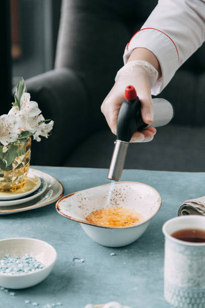 foodstyling von desserts und layout auf einem hölzernen hintergrund. crème brûlée mit kaffee brennen. - brule stock-fotos und bilder