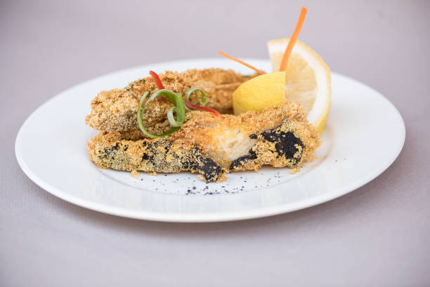istock Grilled carp,  served with lemon and decorated with radish and fresh leaves,  light background,  isolated 1077058948