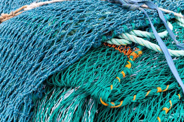 Blue and Green Fishing Net with ropes on a pile.