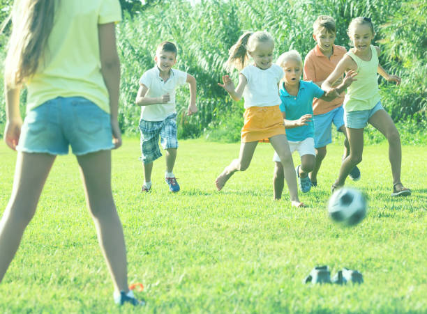 istock children playing football on meadow 1077065930