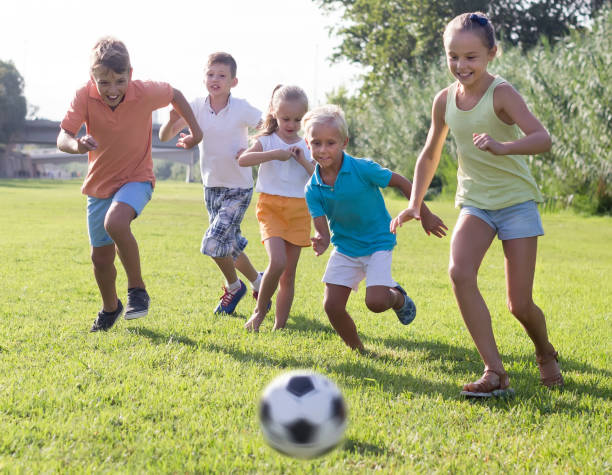 istock children playing football on meadow 1077065974