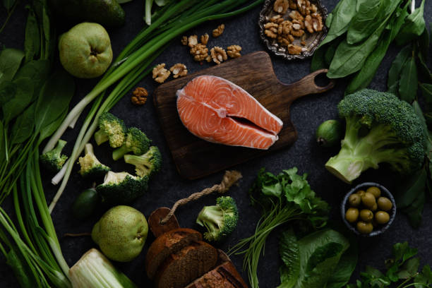 istock Fresh healthy food: vegetables, greens, fruits and raw salmon steak, walnuts and bread. Flatlay composition, top view. Healthy food ingredients concept. 1077078344