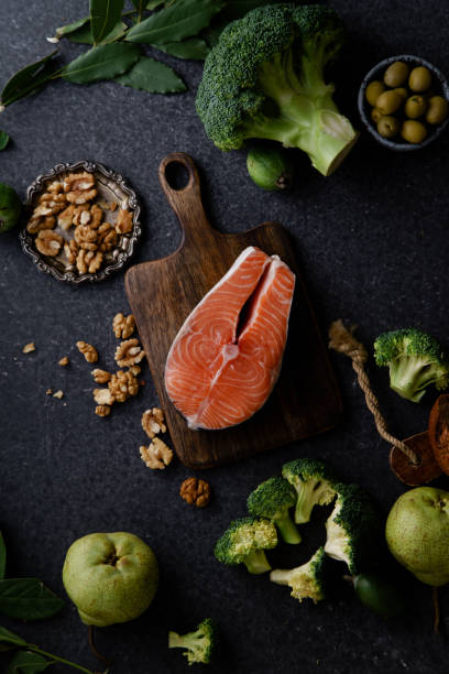 istock Fresh healthy food: vegetables, greens, fruits and raw salmon steak, walnuts and bread. Flatlay composition, top view. Healthy food ingredients concept. 1077078358