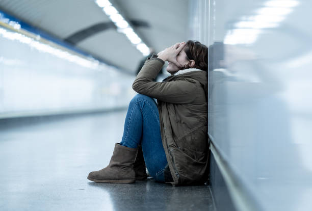 jeune adulte abattage honte déprimé et sans espoir siégeant seul sur la ville de métro sol en santé mentale de solitude dépression émotionnelle douleur relation abusive de la violence sociale et la notion de harcèlement. - drug abuse addiction women violence photos et images de collection