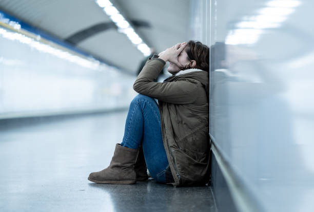 молодые взрослые срубы стыда депрессии и безнадежной сидя в одиночестве на земле города метро в депрессии одиночество психическое здоровь - domestic violence стоковые фото и изображения