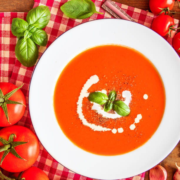 istock Tomato Soup composition with fresh tomatoes, basil leaf and garlic on a wood table, view from above. Vegetarian Autumn Food 1077081240