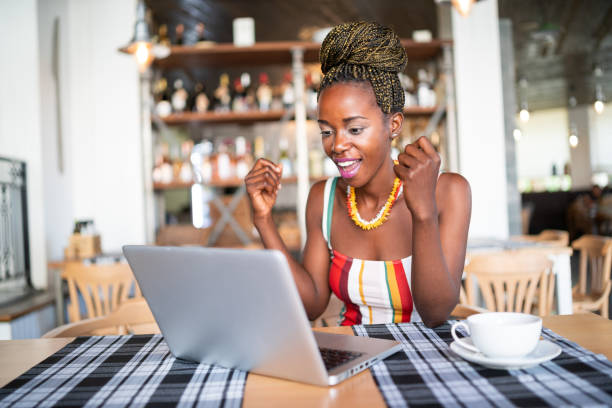 istock African woman drinking coffee and using laptop in cafeteria 1077081270