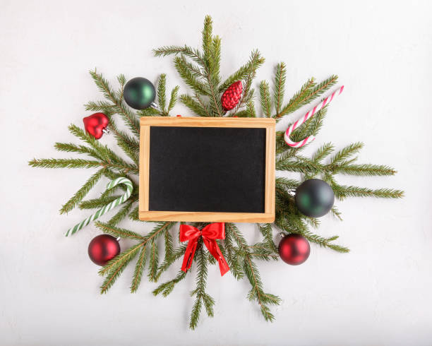 istock Christmas composition. New Year background. Festive xmas fir tree branches and blank chalkboard. Top view. Copy space. 1077081618