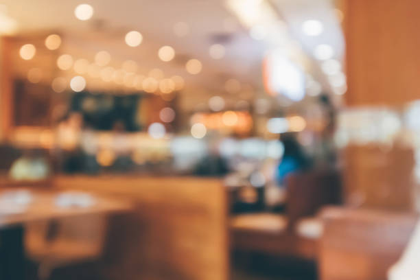 istock Cafe Restaurant interior with customer and wood table blur abstract background with bokeh light 1077084308