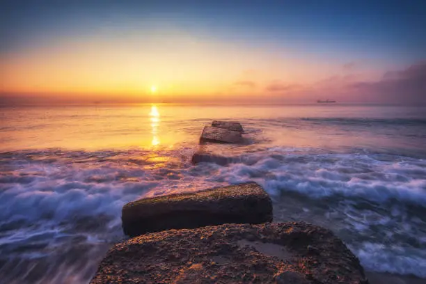 Photo of Sea sunrise with beautiful cloudscape over rocky coastline
