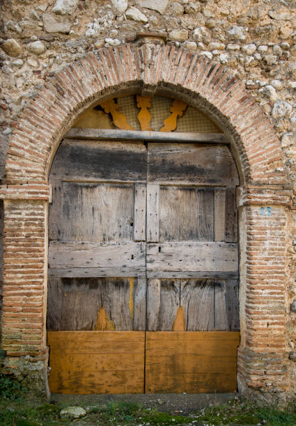 istock Ancient wooden door in old stones brick wall 1077087554