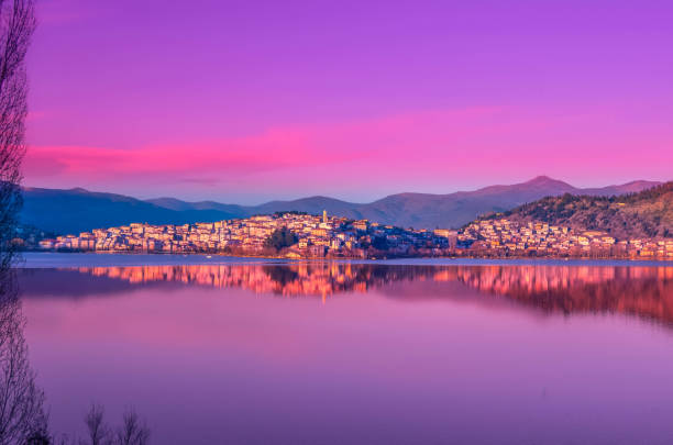The picturesque city of Kastoria reflected on the lake of Orestiada at sunset. stock photo