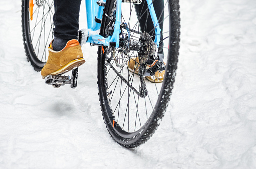 Cyclist on cyclocross bike trails in the snowy forest in winter. Winter workout outdoors concept