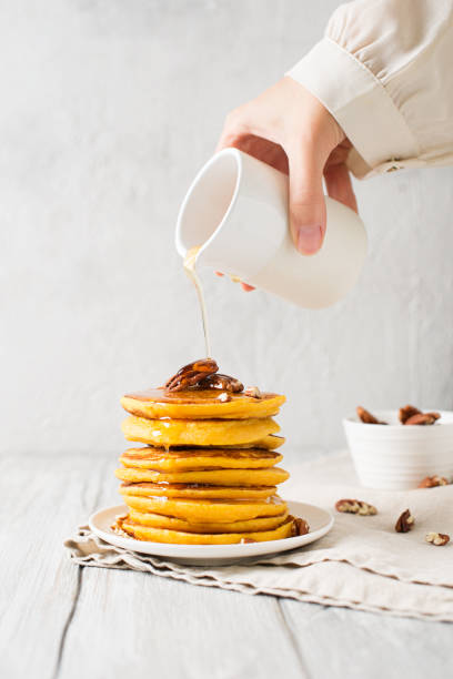 istock Stack of pancakes with pecan and syrup in nordic style 1077089896