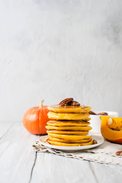 istock Stack of pancakes with pecan and syrup in nordic style 1077089944