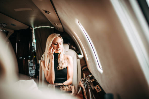 istock Young businesswoman having a conversation on a smart phone while flying in a private jet 1077090206