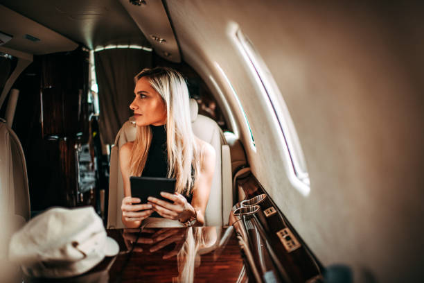 istock Rich blonde businesswoman using a digital tablet while traveling with a private airplane 1077090464